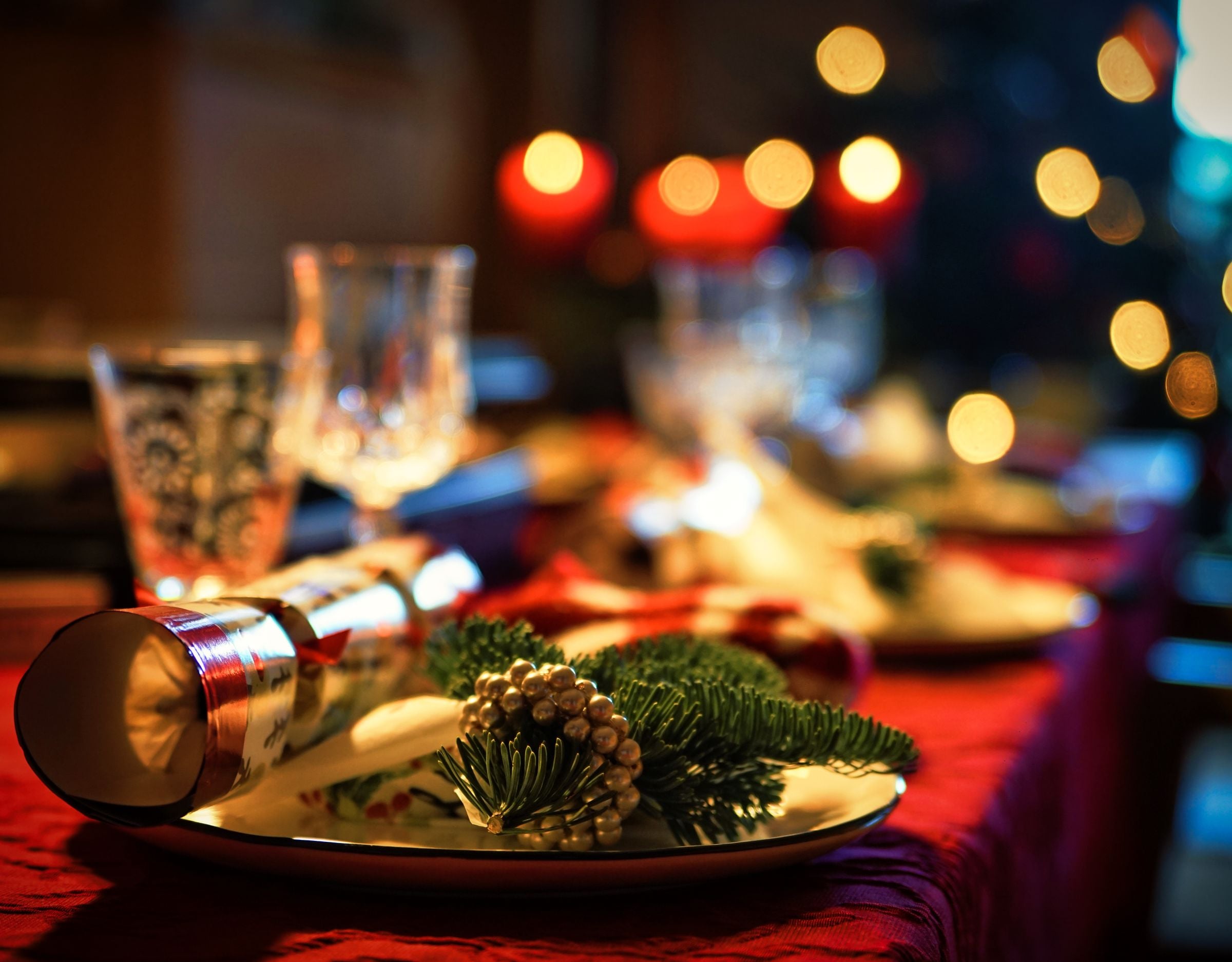 Plat de Nadal decorat amb pinyes i branques, amb llums de fons