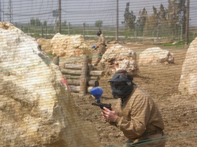 Jugador de paintball protegit darrere d’una roca