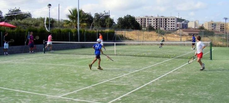 Nens jugant a tennis a la pista