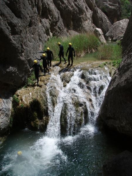 Grup baixant un barranc al costat d’una cascada